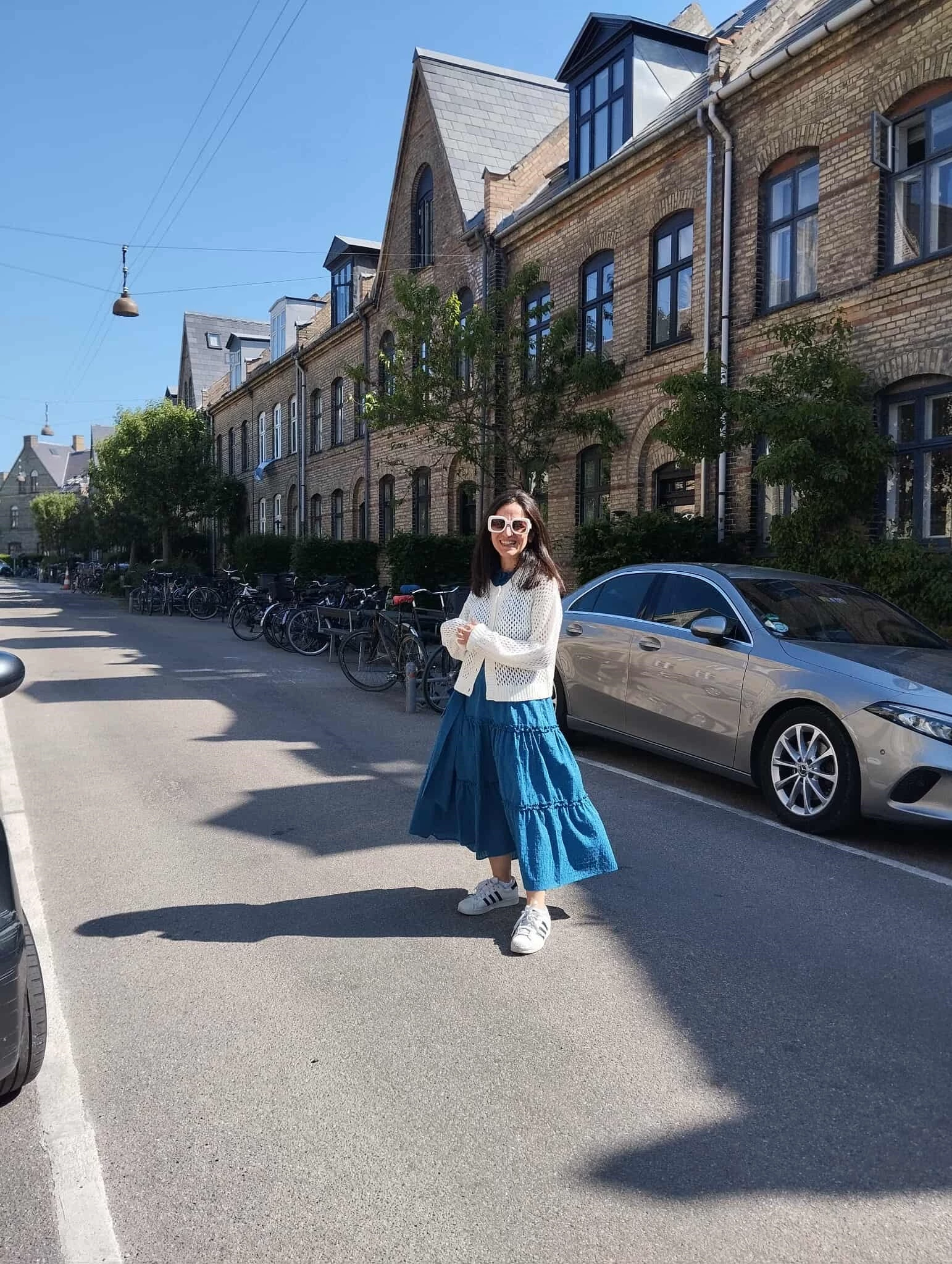 Δήμητρα Βγενοπούλου, fashion editor: Look με μίντι φόρεμα σε μπλε χρώμα,λευκή ζακέτα και sneakers.