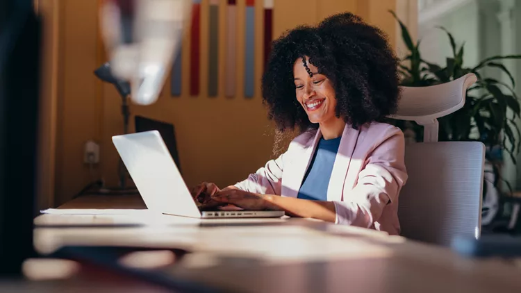 Young black businesswoman working with laptop in modern office