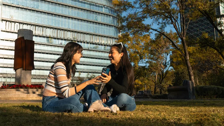 Two Women Laughing Together in Urban Park Setting