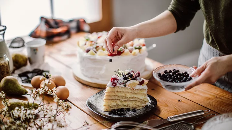 Woman cut a piece of cake for the birthday celebrant