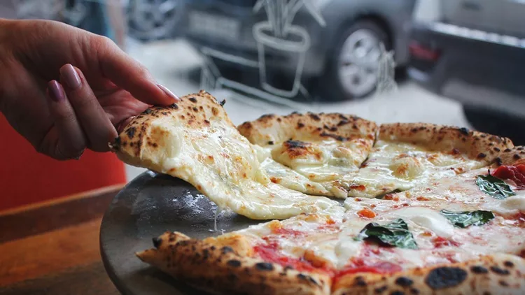 Woman Hand Taking Slice Of Pizza Gorgonzola. Pizza Margarita and Gorgonzola. Close up of Pizza and Hand