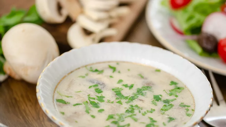 Musroom soup served with chicken cutlet and parsley leaf. (shallow depth of field)