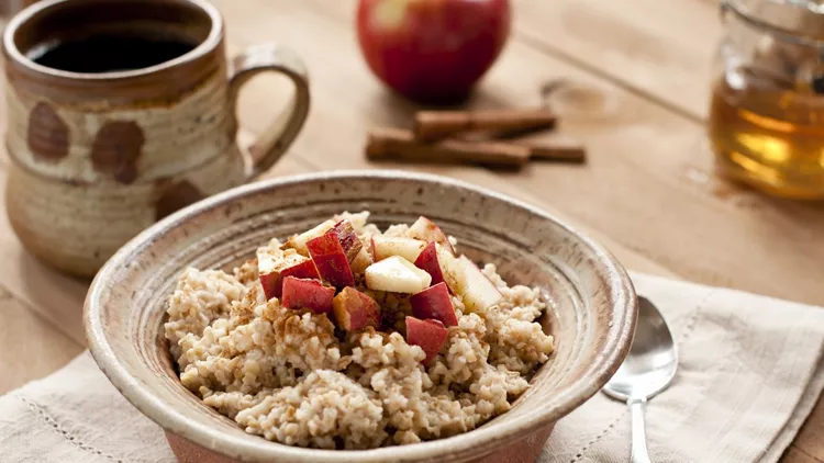 Breakfast made of oatmeal with apples, honey and cinnamon