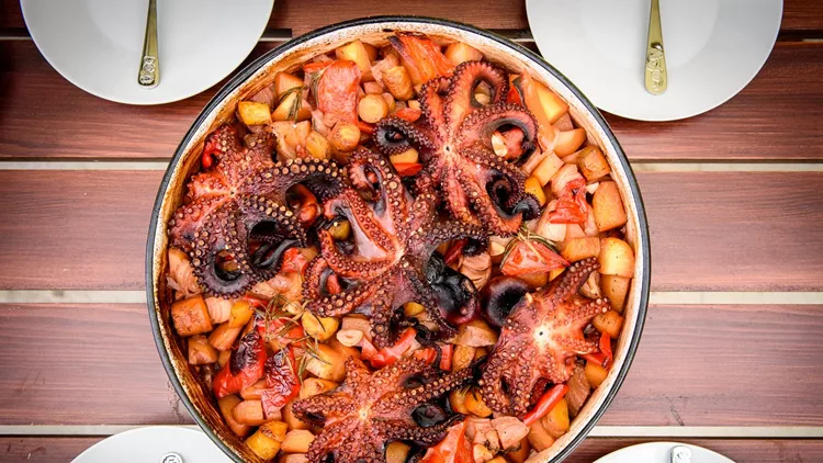 Preparing and Cooking of octopus in traditional Croatian peka Sa