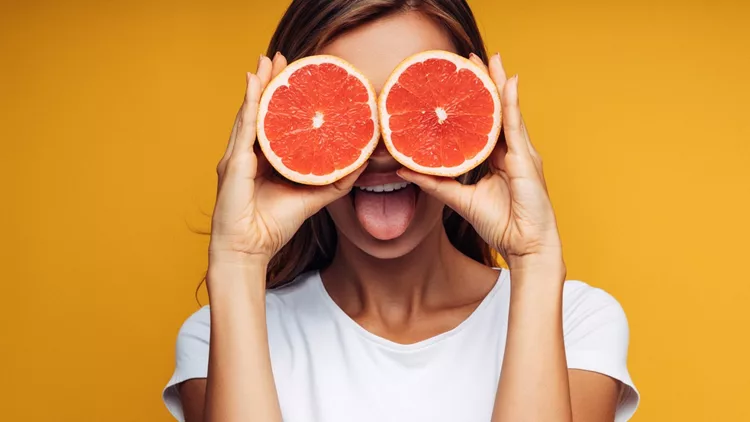 Portrait of girl holding red grapefruit