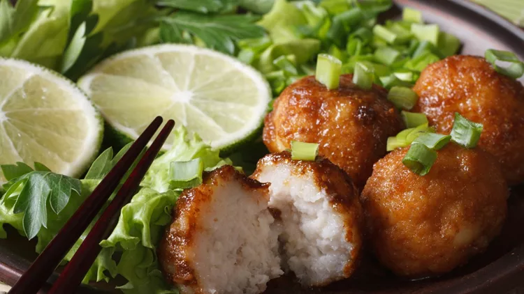 fish balls with lime and salad on plate macro. horizontal