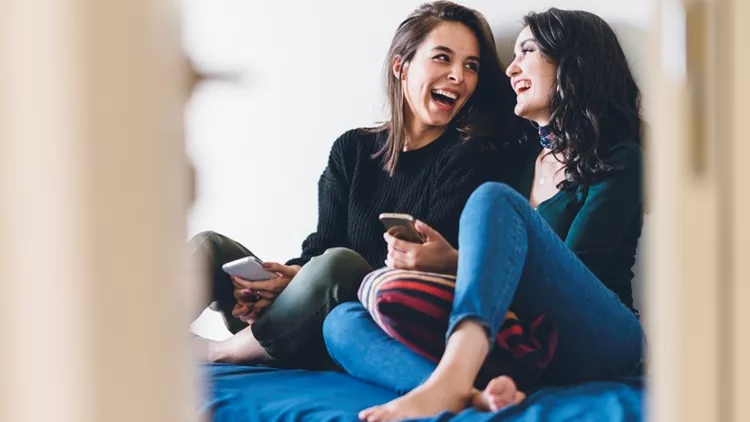 Two young women friends sharing happy time together