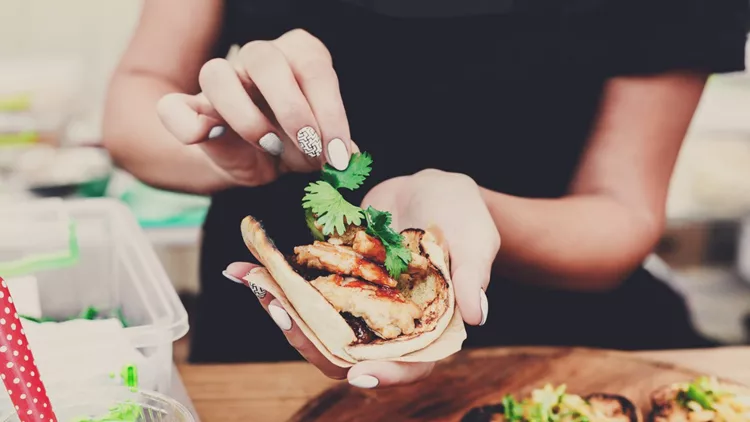 Street vendor hands making taco outdoors