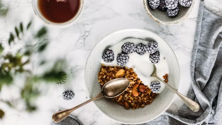 having-breakfast-granola-and-yogurt-woman-summer-concept-picture-id694168582