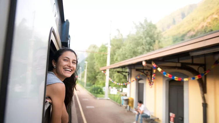 Smiling woman looking at the view from train.
