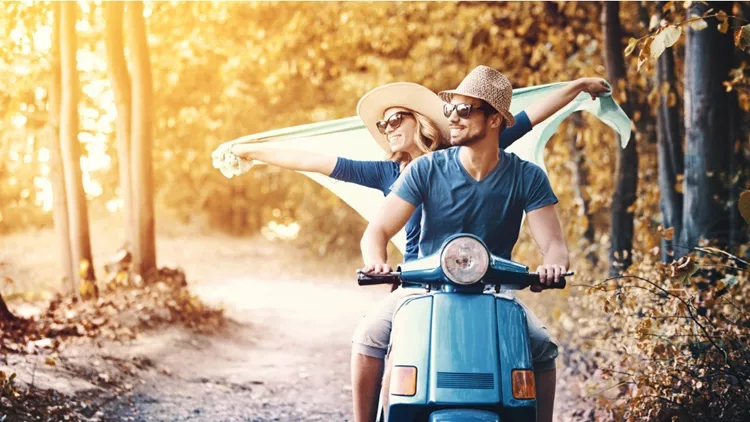couple-on-a-scooter-bike-driving-through-countryside-picture-id928431290