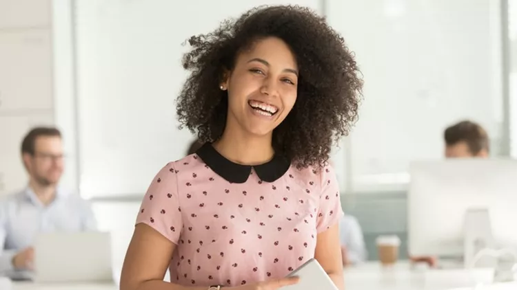 Happy african businesswoman holding digital tablet looking at camera