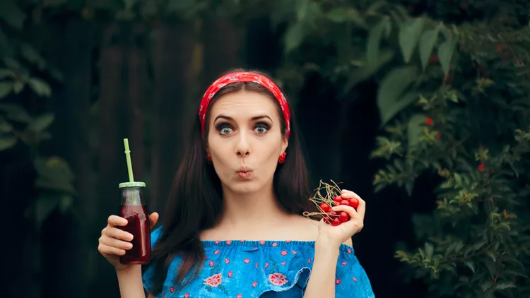 Girl Choosing Between Fruit Juice and Fresh Cherries