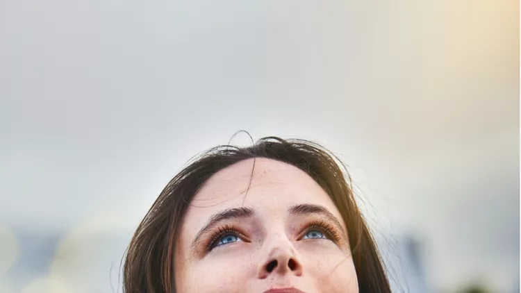 young-woman-looks-hopeful-as-she-raises-her-eyes-towards-the-sky-picture-id911330238 (1)