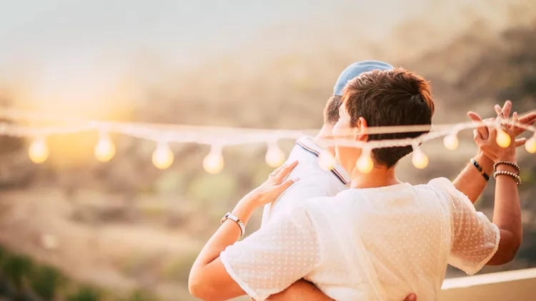 beautiful couple dancing on the terrace rooftop with natural view. love and dating concept for people having romantic leisure activity together with love and tenderness. foreverness concept and sunset time