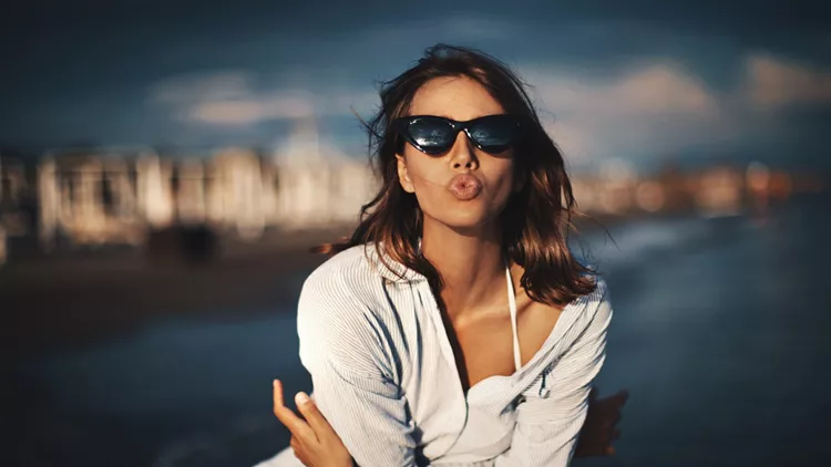 Woman enjoying sunset at a beach.