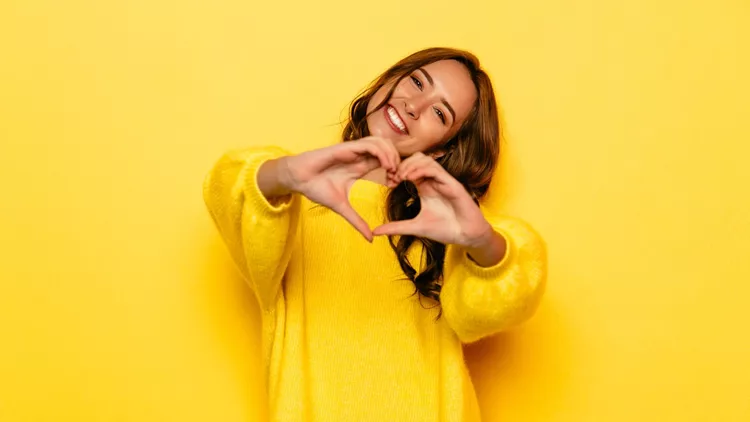 Beautiful girl showing heart with two hands