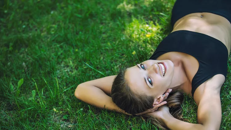 Beautiful young woman lying on the grass