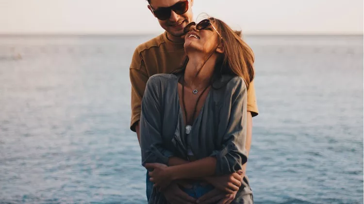 millennial-couple-enjoying-spring-picnic-by-the-beach-picture-id940674076