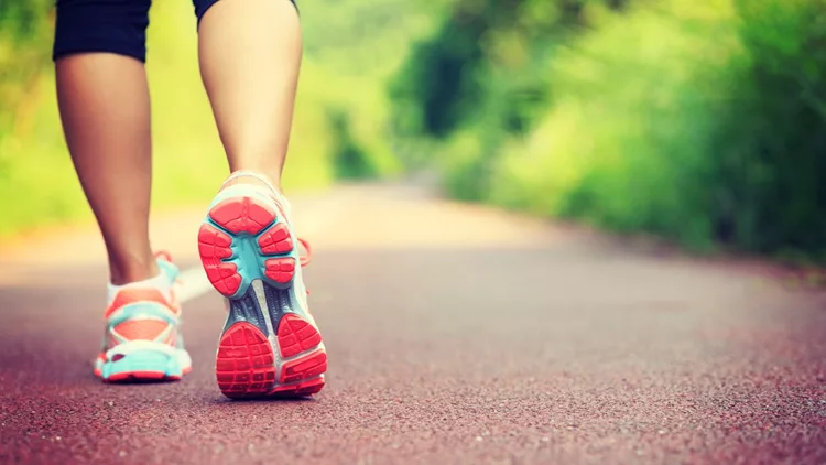 Young fitness female runner legs ready for run on forest trail