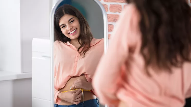 Happy Woman Measuring Waist With A Tape