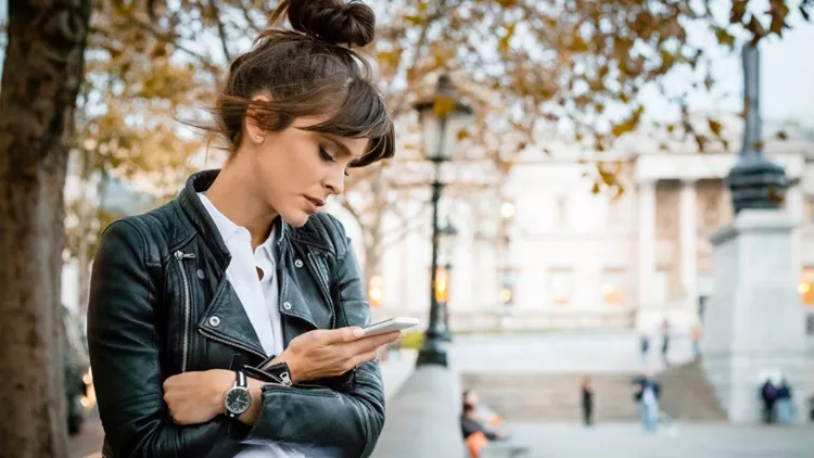 worried-woman-using-smart-phone-at-trafalgar-square-in-london-autumn-picture-id855778422