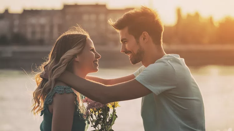 Man giving flowers to girlfriend