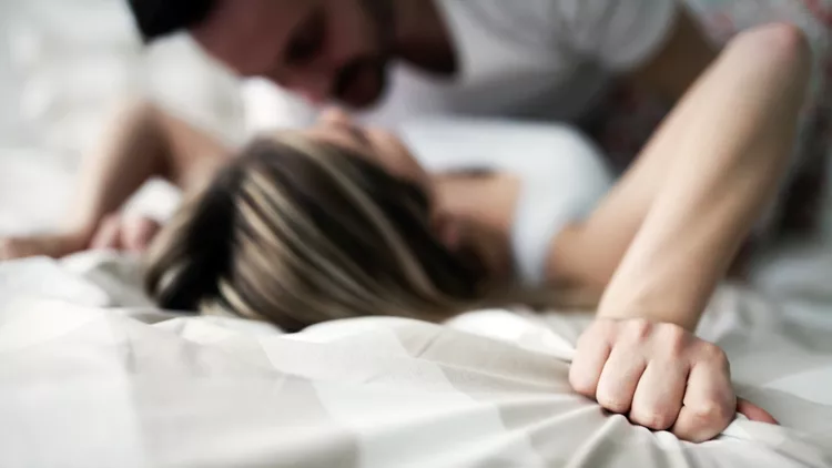 Young attractive couple having romantic time in bed