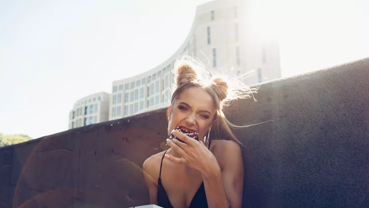 Portrait of funny beautiful girl eating donut
