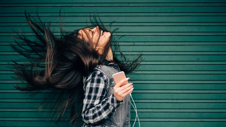 Teenage girl listening to the music and shaking head