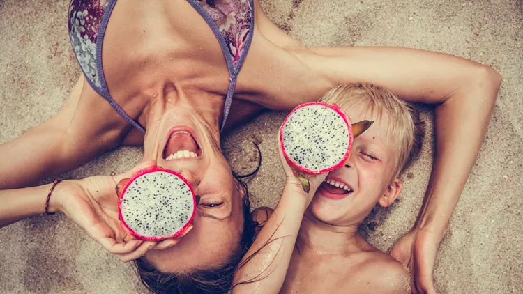 Happy  woman  and boy puts dragon fruit as glasses.