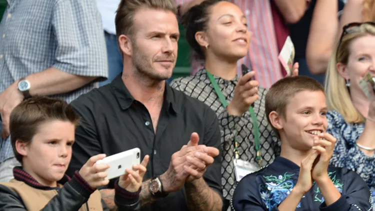 Former England footballer David Beckham (C) and his sons Cruz (L) and Romeo (R)  on centre court for men's singles quarter-final match on the tenth day of the 2016 Wimbledon Championships at The All England Lawn Tennis Club in Wimbledon, southwest Lo