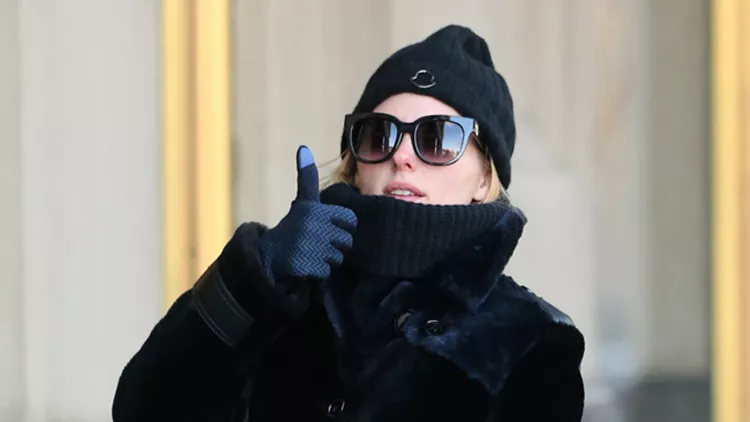 Fashion blogger Olivia Palermo, wearing a blue-purple overcoat and knit cap, walks her dog Mr. Butler, wearing a down jacket and little yellow boots, in Brooklyn, New York