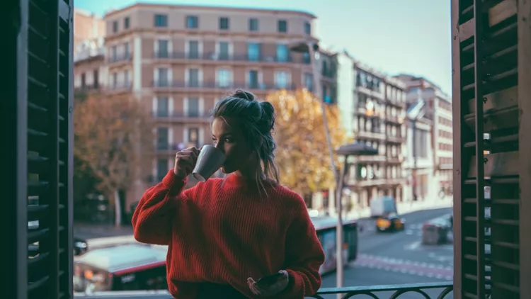 Girl drinking coffee at the balcony in Barcelona