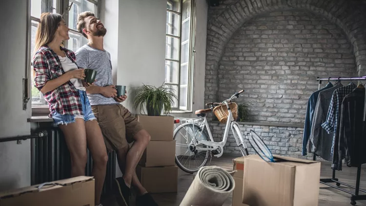 Young cheerful couple communicating after relocating into new apartment.