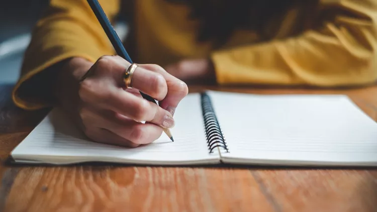 Close up woman hand writing on notebook