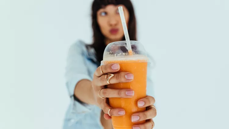 Woman offering fresh orange juice