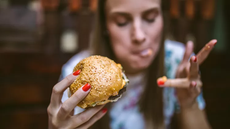 Woman Enjoying Delicious Burger