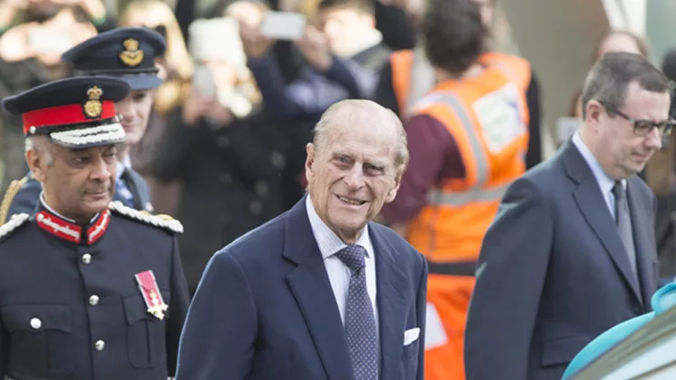 Queen Elizabeth and Prince Phillip wave to fans as they leave the cyber security centre in Victoria, London.