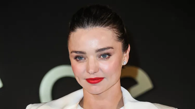 Miranda Kerr wearing an August Getty dress, Tamara Mellon shoes, and Cartier jewelry while carrying a Jimmy Choo clutch arrives at the Panthere De Cartier Party