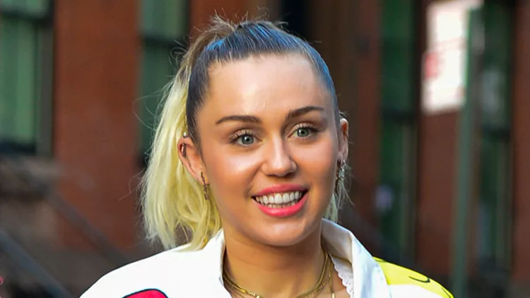 Miley Cyrus spotted out in painted white denim outfit with matching high boots with friends.