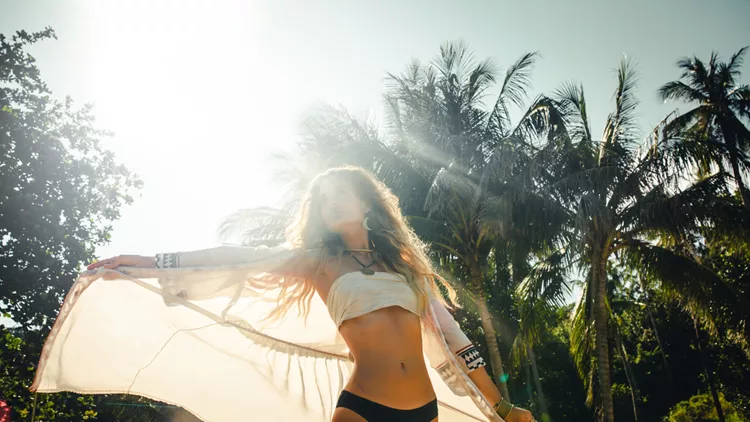 Beautiful young woman walking along a tropical beach