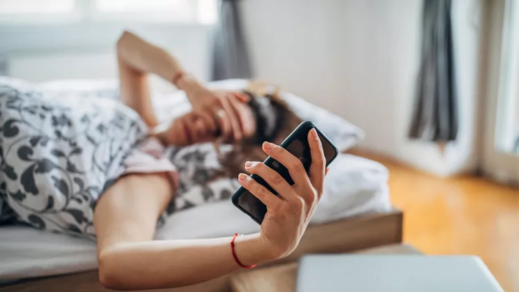 Young woman is snoozing alarm