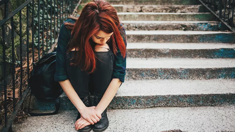 Sad lonely girl sitting on stairs