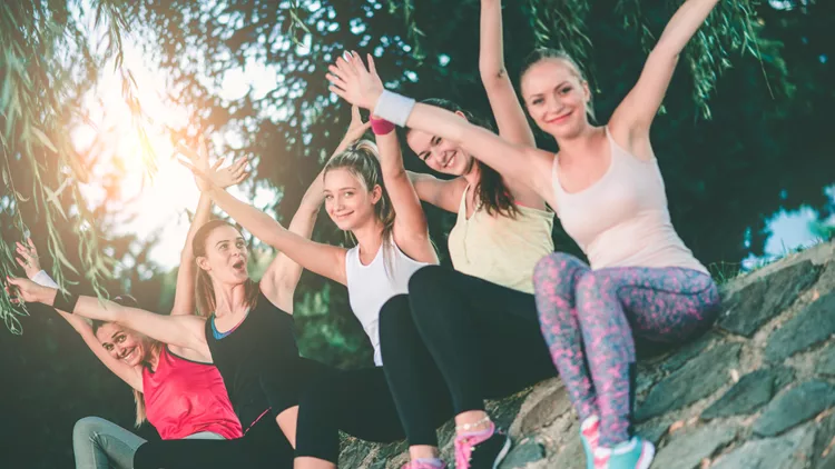 Group of Female with Raised Hands After Exercise in Nature