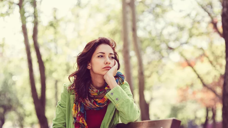 Unhappy girl sitting at bench