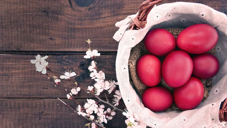 Basket with easter cake and red eggs  wooden table