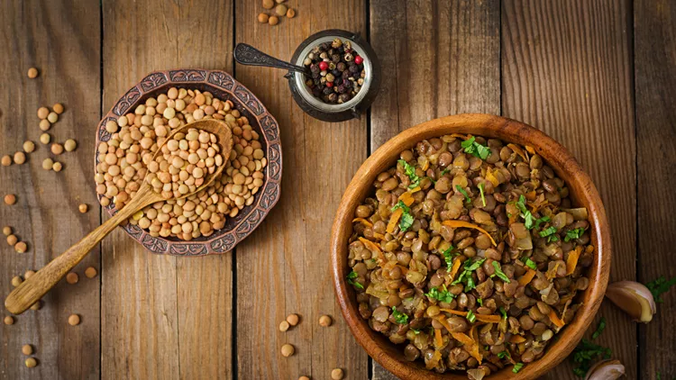 Lentil with carrot and onion in wooden bowl. Healthy lifestyle. Diet menu. Flat lay. Top view