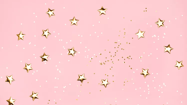 Golden stars glitter on pink background.