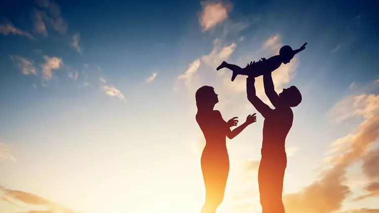Happy family together, parents with their little child at sunset.
